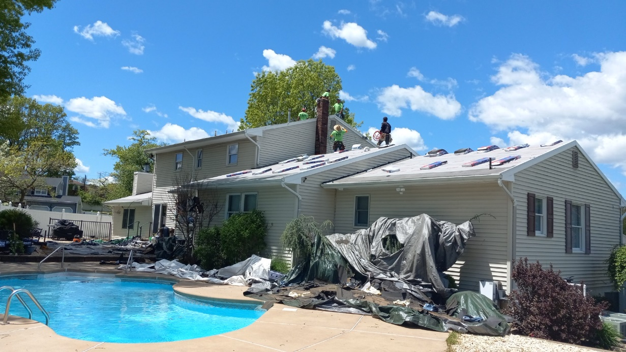 Roofing contractors in Sayreville, NJ, inspecting a roof for damage.